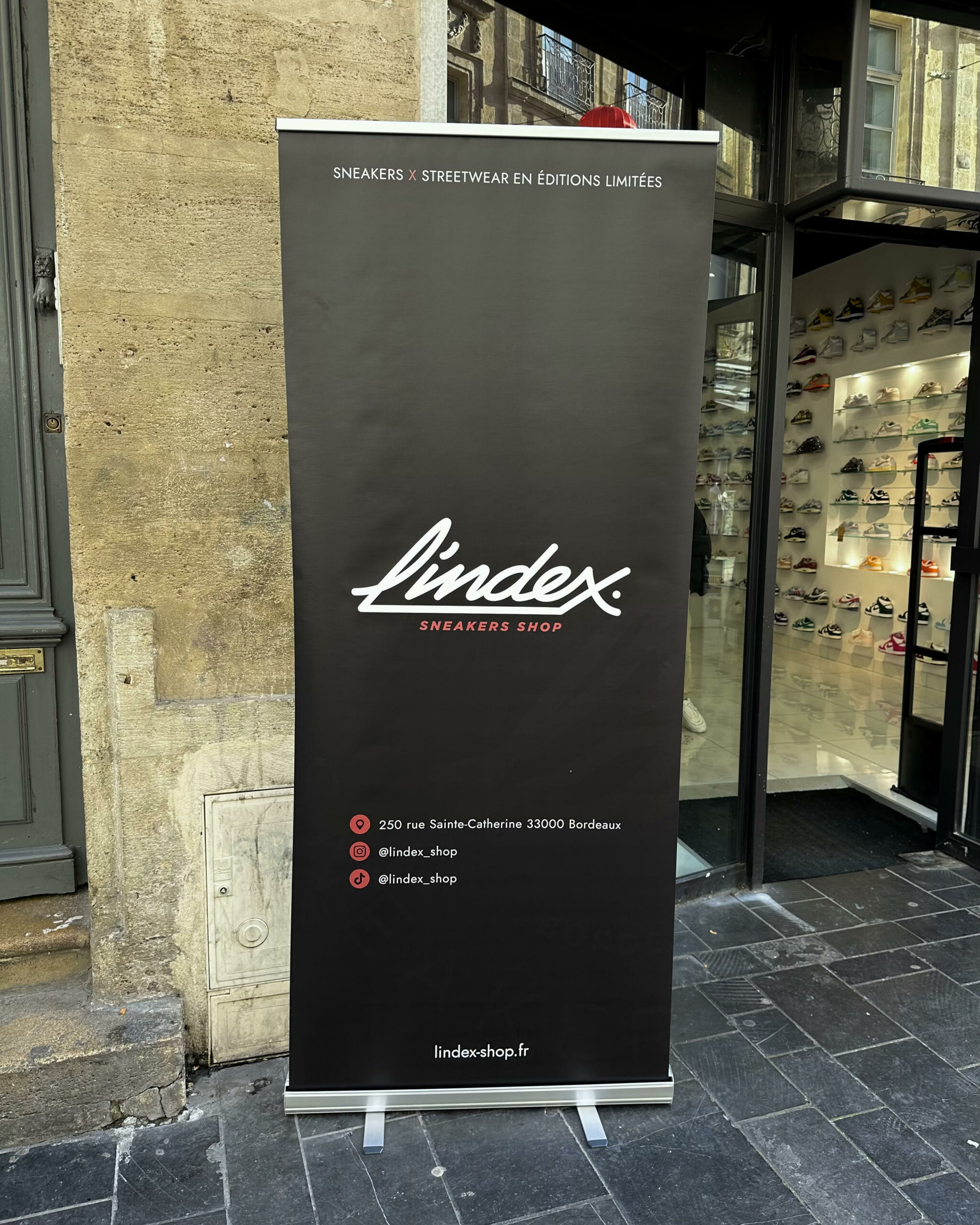 Photo du roll-up de L’Index Shop devant la boutique de sneakers à Bordeaux, rue Sainte-Catherine.