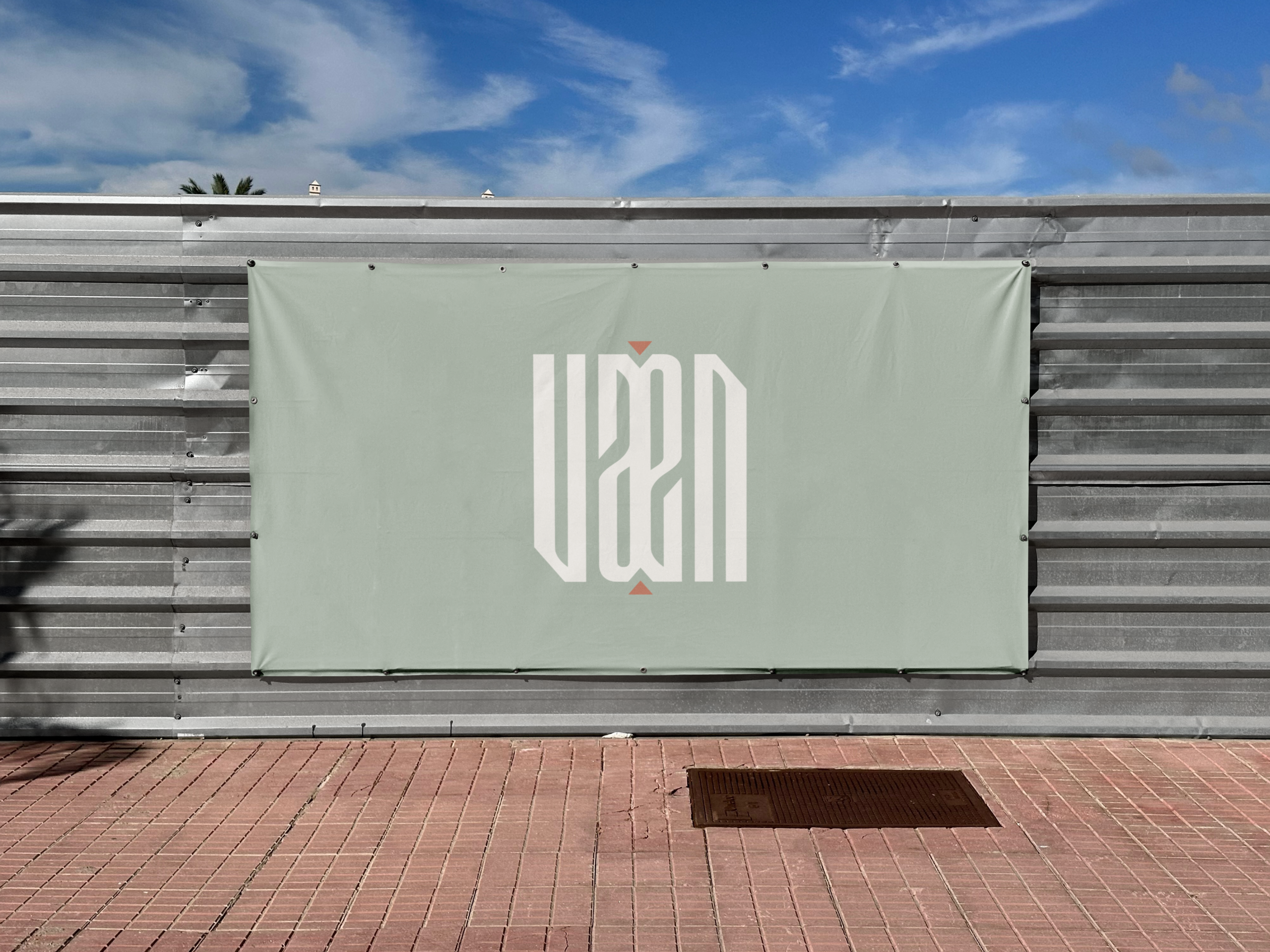 Bâche publicitaire VAEN sur palissade en métal.