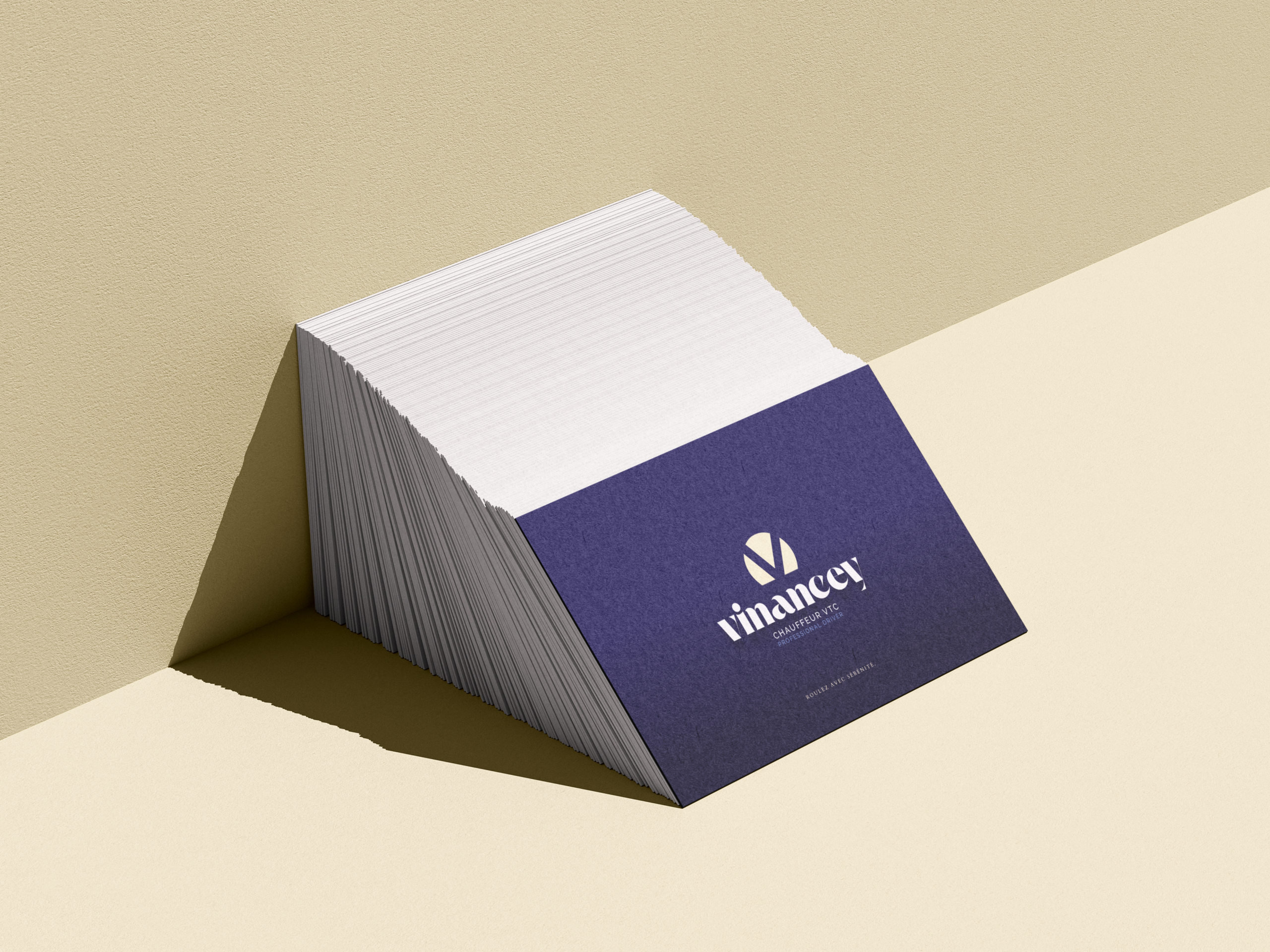 Cartes de visite avec icône de marque beige et logotype blanc sur fond bleu foncé.