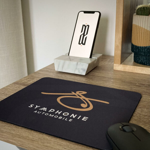 Souris d'ordinateur sur tapis de souris gris avec logo Symphonie Automobile.
